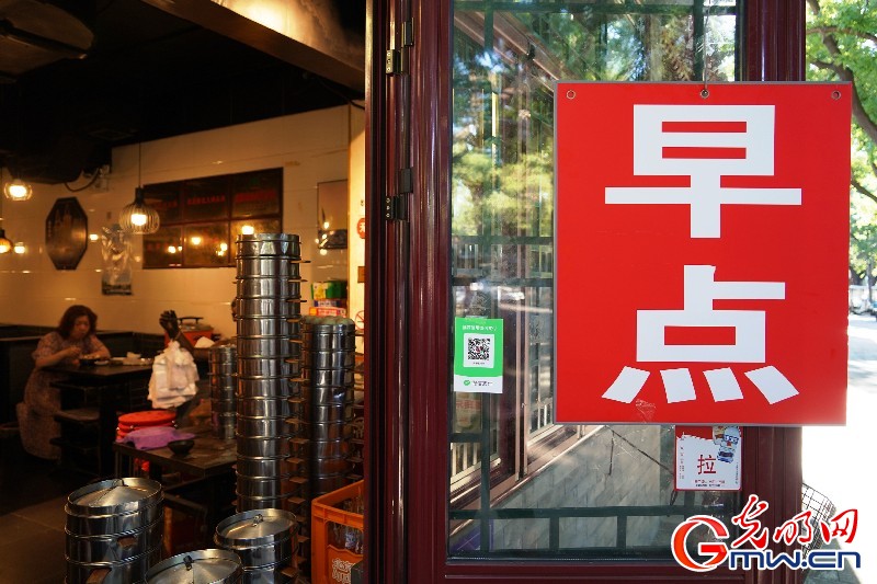 2022年6月6日，北京，西城区西安门大街，市民在街边餐饮店内享用早餐。（光明图片/视觉中国）
